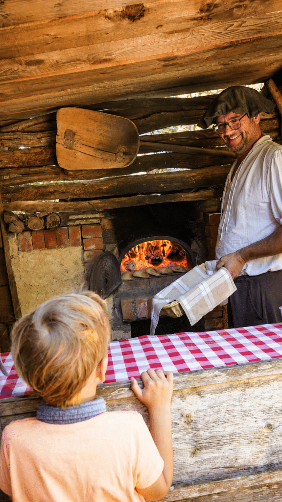 Boulanger préparant des fouées traditionnelles au feu de bois devant des visiteurs à la Vallée Troglodytique des Goupillières