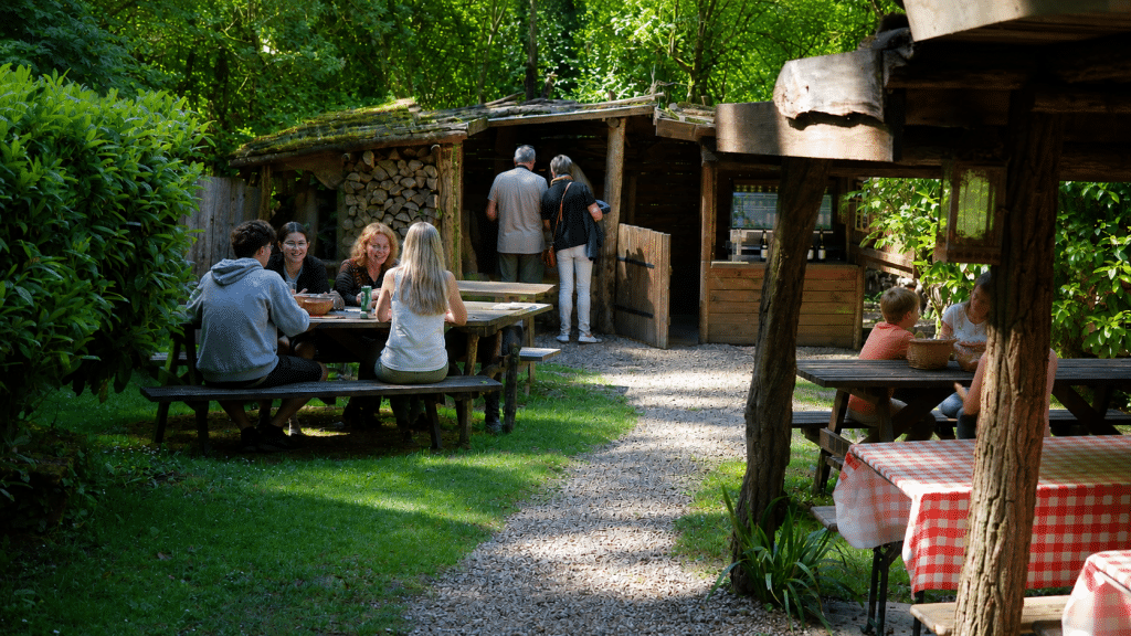 Visiteurs profitant d’un repas convivial en terrasse dans le village troglodytique des Goupillières en Touraine
